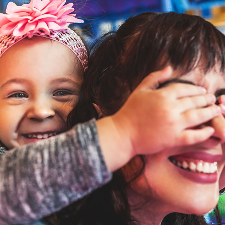 Toddler covering woman's eyes